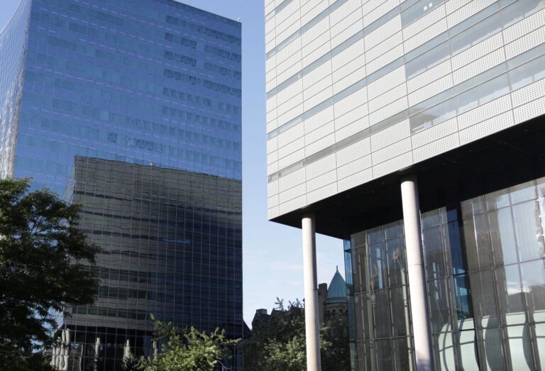 Modern glass office buildings against blue sky.